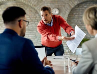 Candidat mécontent discutant de son CV avec l'équipe des ressources humaines lors d'un entretien d'embauche au bureau.