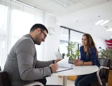 il s'agit d'un homme et d'une femme sur un bureau entrain de faire un entretient d'embauche