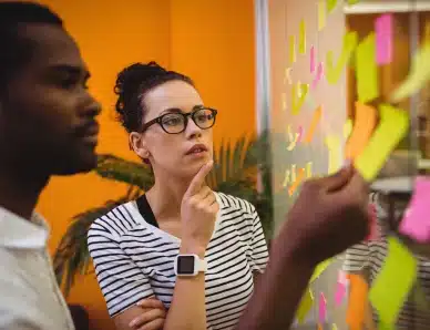 il s'agit d'une photo d'un homme et une femme posant des post it sur un mur