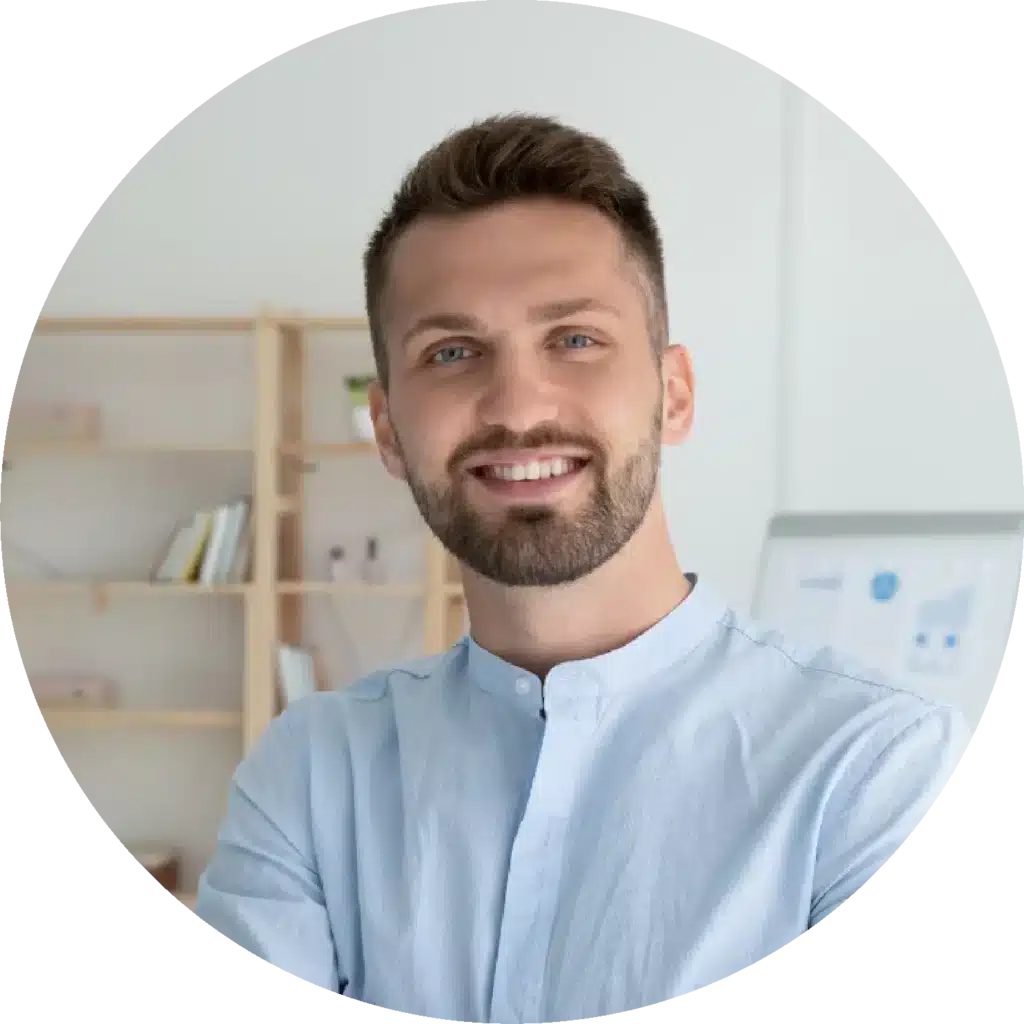 Portrait d'un homme souriant avec une chemise bleu clair, dans un bureau moderne