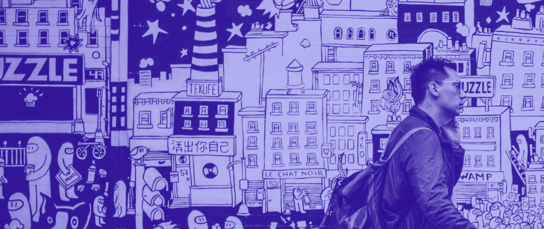 Homme au téléphone devant une fresque murale urbaine