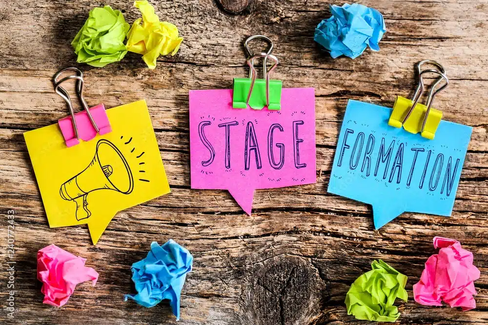 Post-it colorés avec les mots stage et formation sur fond en bois