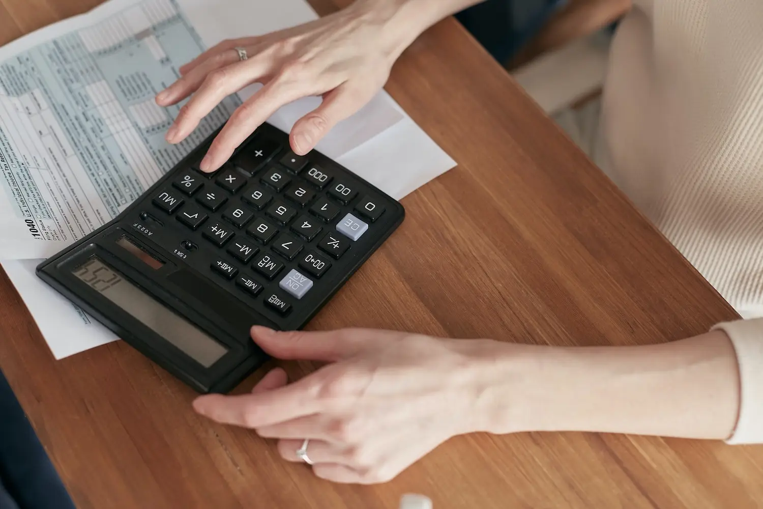 Personne utilisant une calculatrice avec des documents financiers