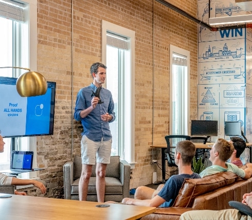 Un homme faisant une présentation devant un groupe dans un espace de coworking