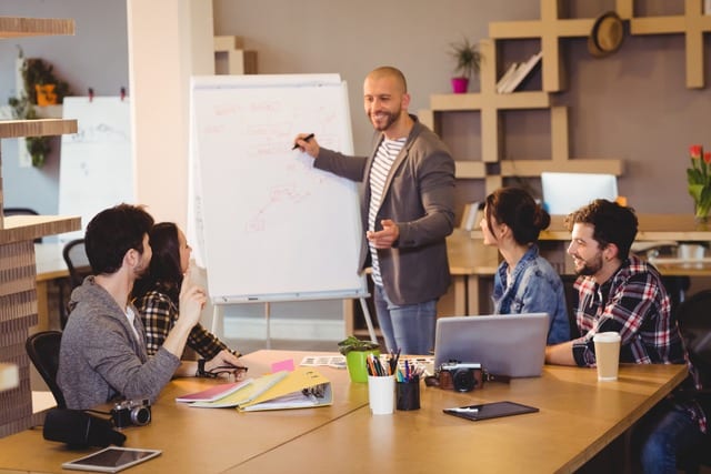 Formateur souriant animant une session de formation en entreprise